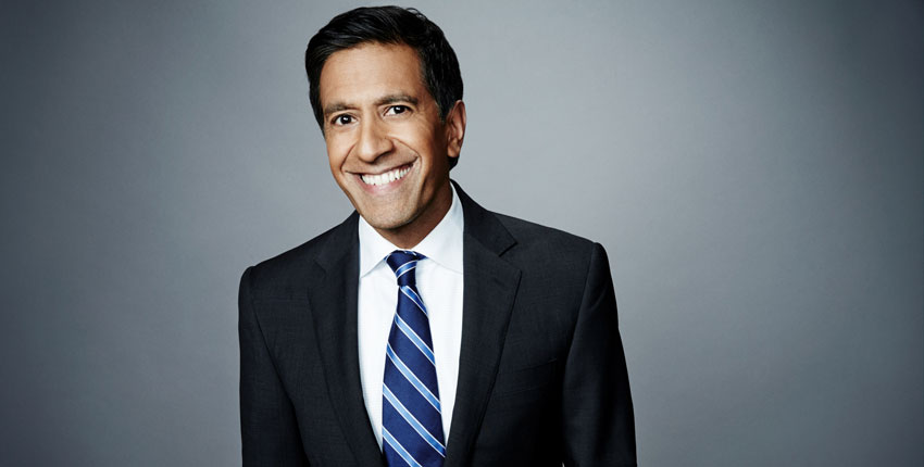 Man in a blue suit and stripe tie smiling