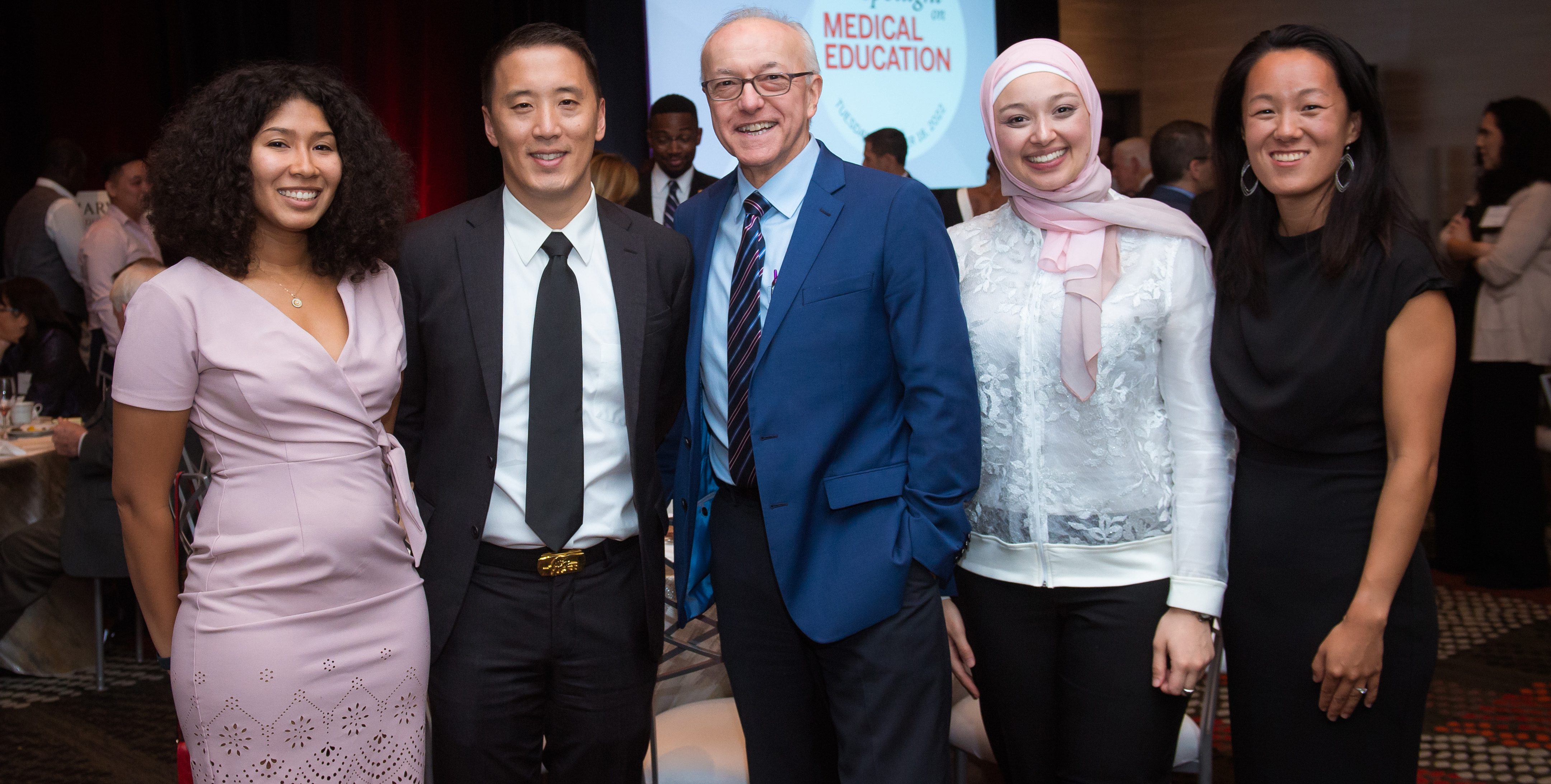 Photo of 4 students and former student with Dean Daley, all smiling at the camera