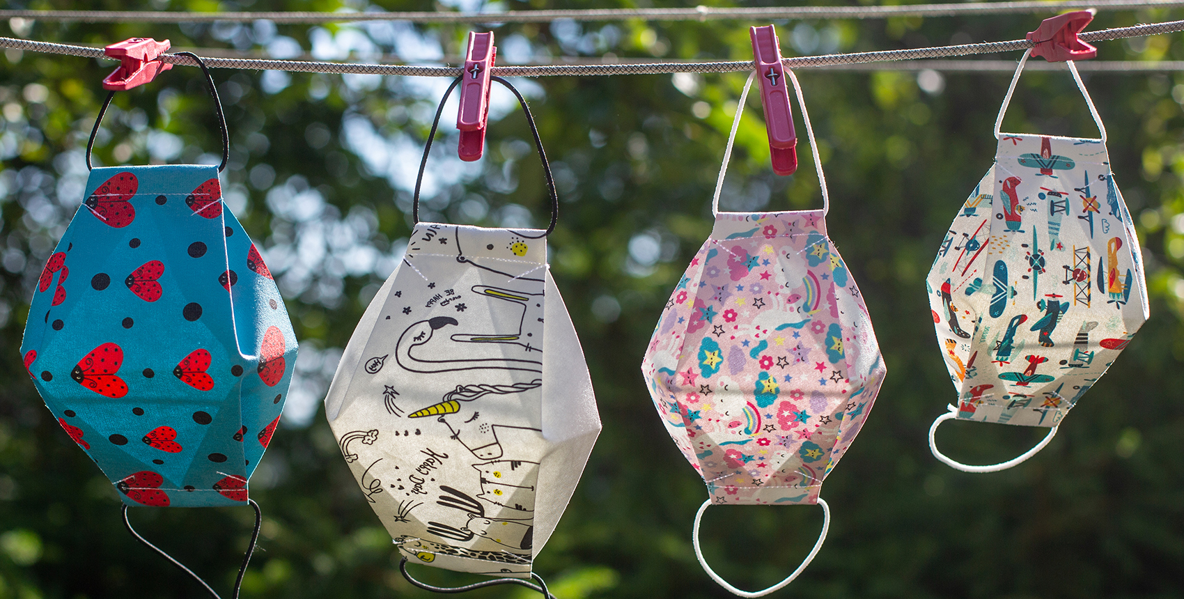 Diverse, colorful masks hang on a laundry line.