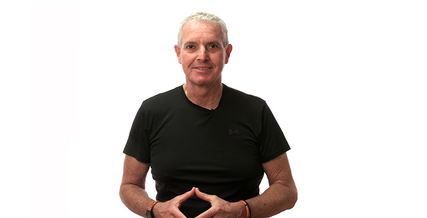 head and torso of a gray-haired man against a white backdrop