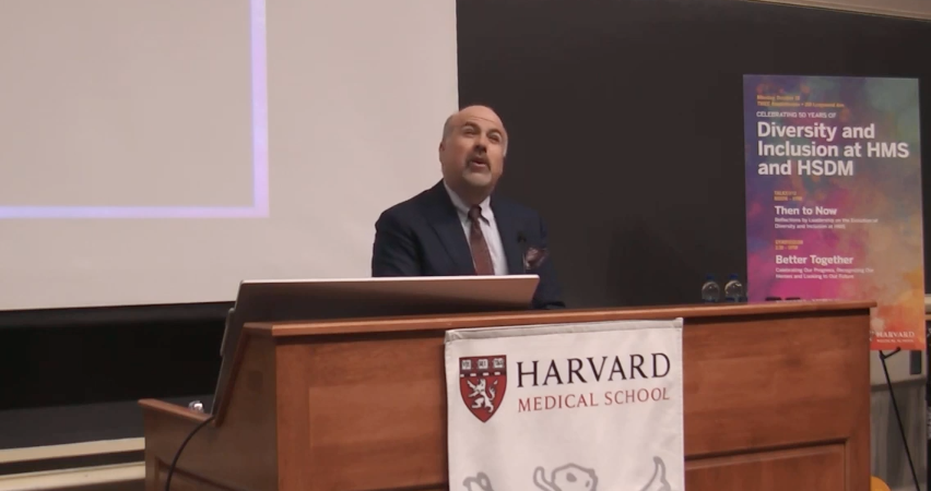 A man at a podium reads a poem