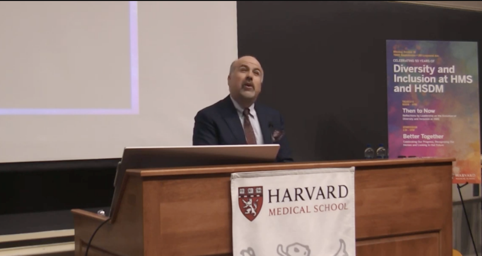 A man at a podium reads a poem