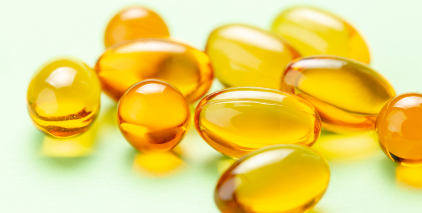 photo of vitamin D capsules on a light green background