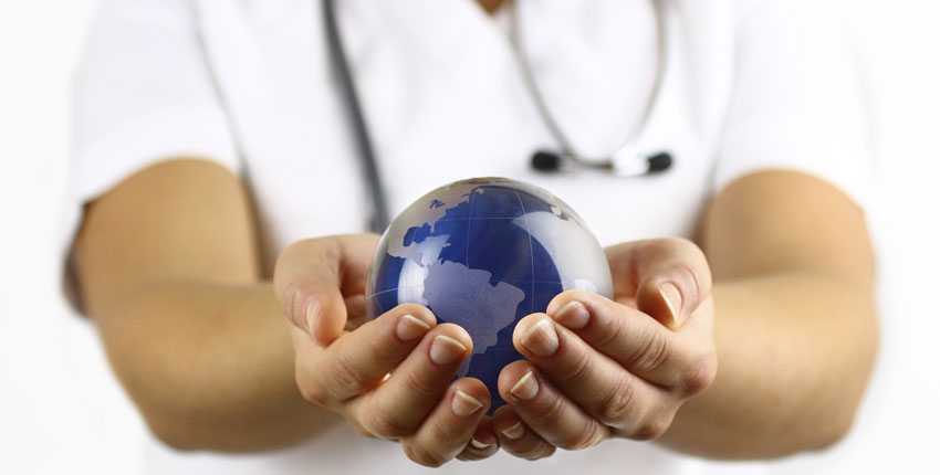Stock image of white coated person holding a small earth globe