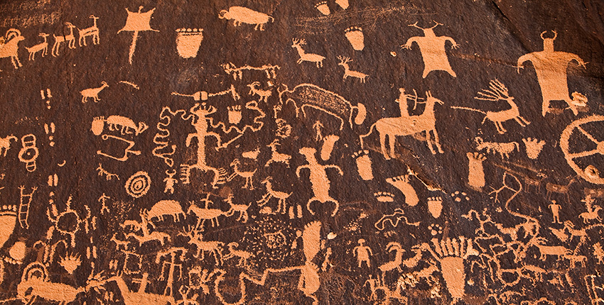 arte rupestre antiguo que muestra personas y animales.