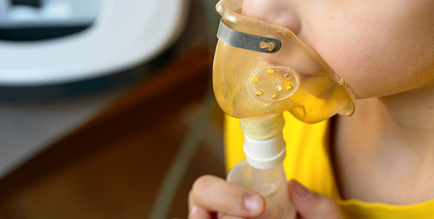 close up of child's face making an inhalation with a nebulizer