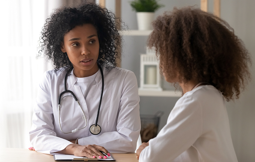 Young Black doctor has serious conversation with pediatric patient of color