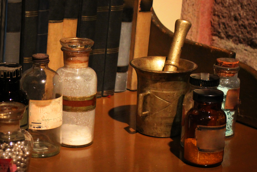 Antique medication bottles, mortar and pestle, and powders