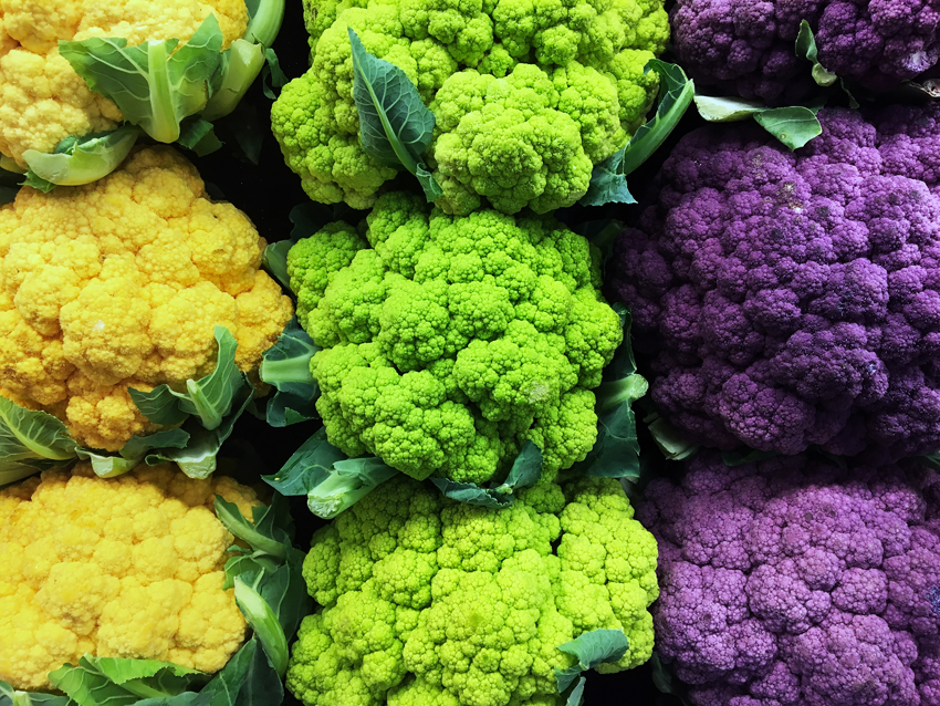 Brightly colored cauliflower crowns--yellow, green, purple