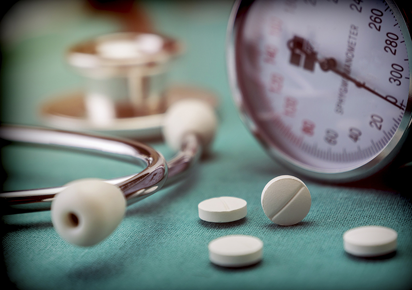 stock image of blood pressure cuff and pills with stethoscope