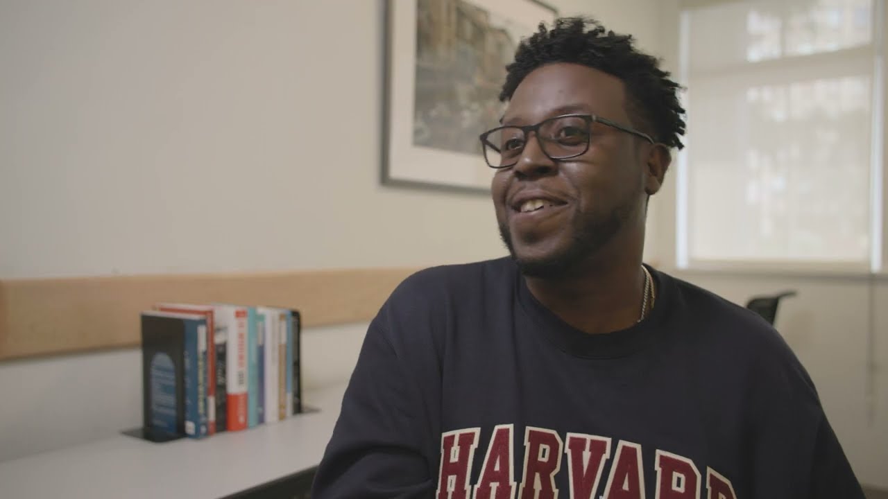 Video thumbnail: a man with glasses sits in an office wearing a Harvard sweat shirt..