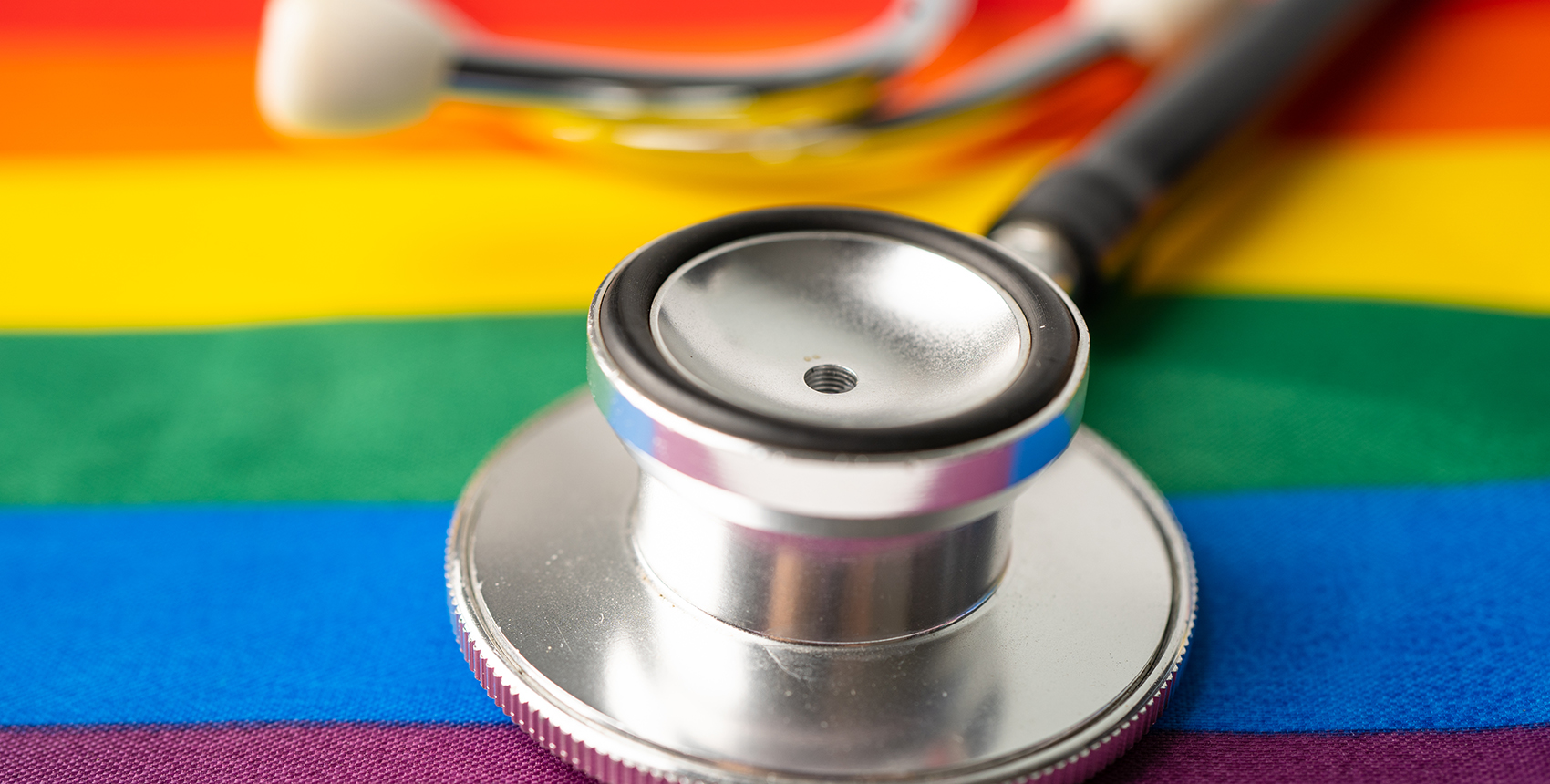 A stethoscope rests on a table covered with  rainbow-colored cloth.