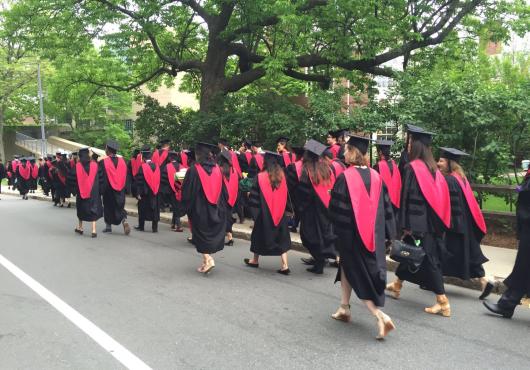 HMS MD grads walking in procession, in caps & gowns, from behind