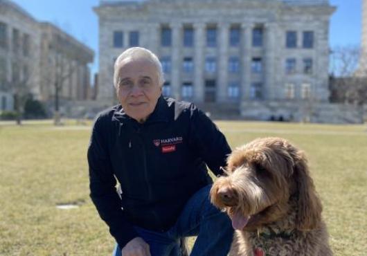 Bill DeSimone and a dog in front of Gordon Hall