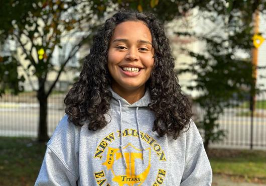 Jasmine Canas smiling, wearing her high school's sweatshirt