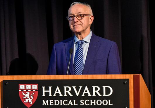 Dean George Q. Daley stands behind a Harvard Medical School podium
