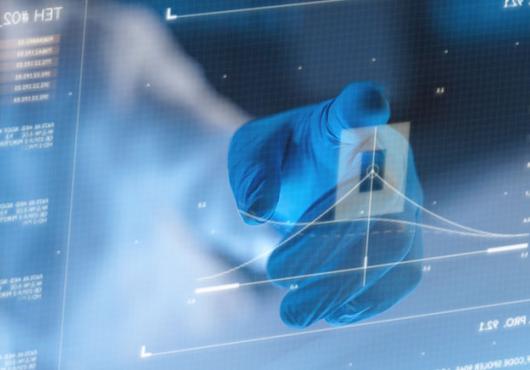A hand in a protective glove, using a futuristic screen to look at a diagram