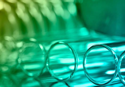 a closeup of test tubes lying on a table lit in green light