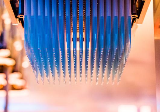Narrow pipettes hanging upside down from a high-throughput screener