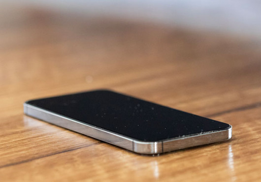 A phone with screen off sitting on a table