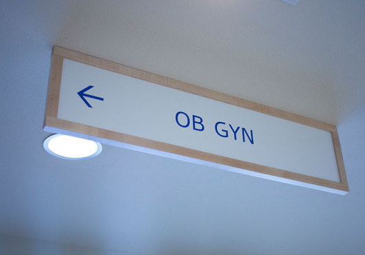 A hospital sign that reads "OB GYN" with an arrow pointing to the left