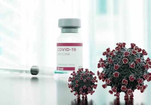 Clinical image showing syringe, vaccine vial, and stylized covid spike proteins