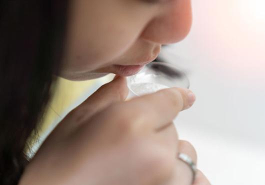 Person spitting into a small cup