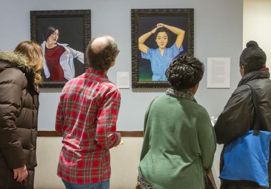 People viewing Chen paintings in the dean's office 