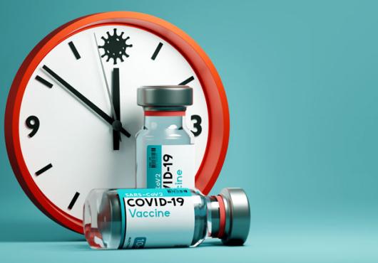 A Clock together with a COVID vaccine vial 