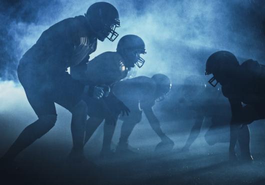 Football players in silhouette on the playing field