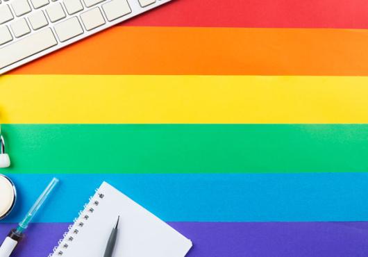 stethoscope, computer keyboard over pride colors