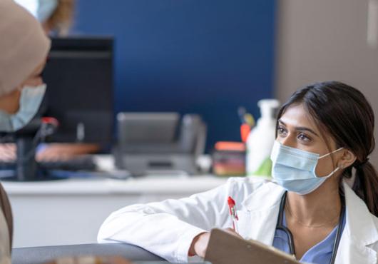 Photo of a health care provider interviewing a female patient 