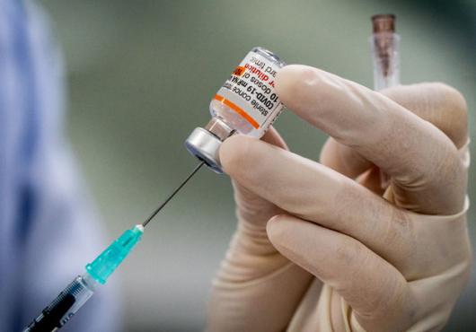 gloved hand with syringe and covid treatment 