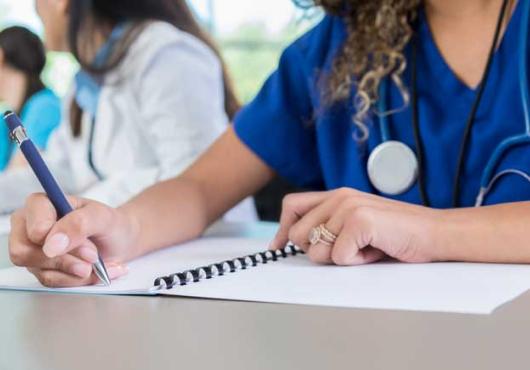 Image of nondescript med students working at a desk
