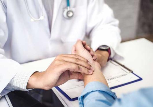 Stock image of a doctor's hands taking a patient's pulse 