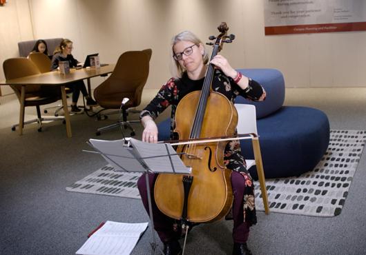 a woman playing cello in Countway Library