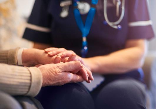 Stock image of caregiver with older patient - hands only