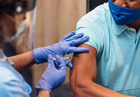 Photo of an African American man getting a vaccination 