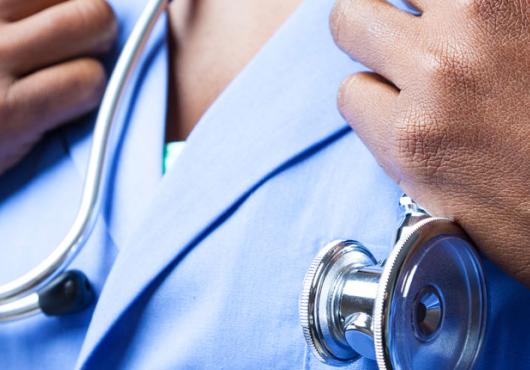 Image of a Black physician, just hands, scrubs and a stethoscope