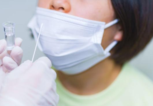 photo of a child with a mask about to get a nose swab for COVID