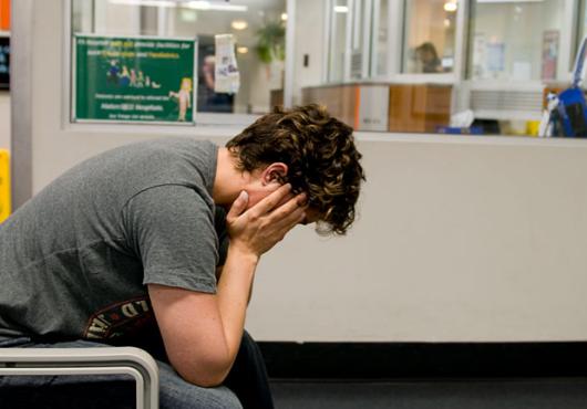 Stock image of a young man with his head in his hands 
