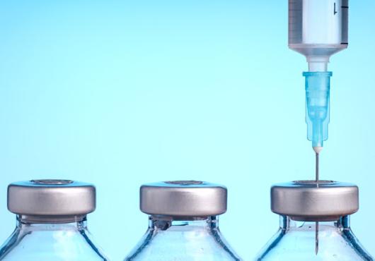 Image of 3 vaccine bottles & a syringe 