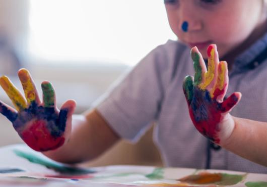 A young child's paint-covered hands.