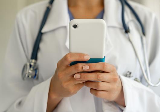 Female physician holding a mobile phone