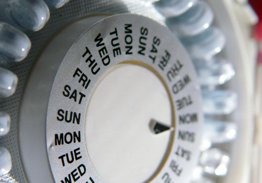 Close-up of a pill organizer listing days of the week.