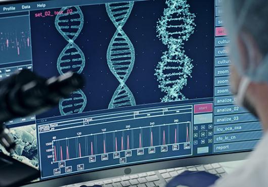 A scientist looks at computer screen showing a DNA sequence