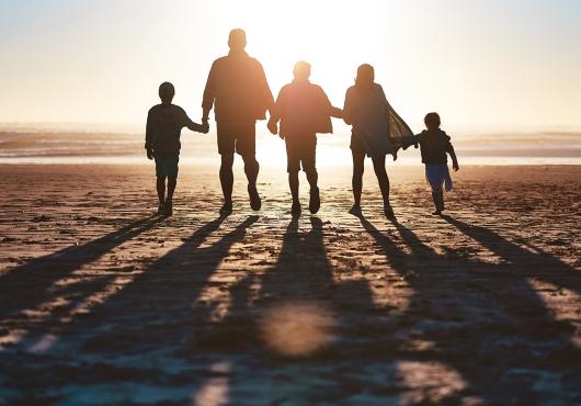 Silhouette of a family going for a walk together along the beach