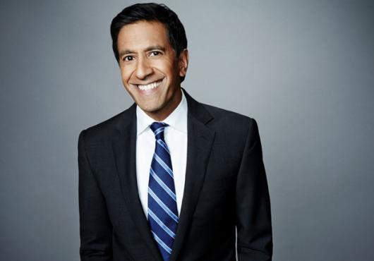 Man in a blue suit and stripe tie smiling
