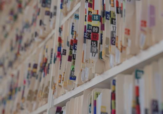 Colorful folders on a crowded shelf