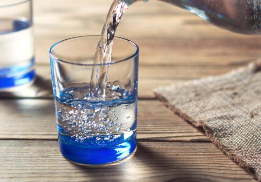 Photo of water being poured from a pitcher into a glass